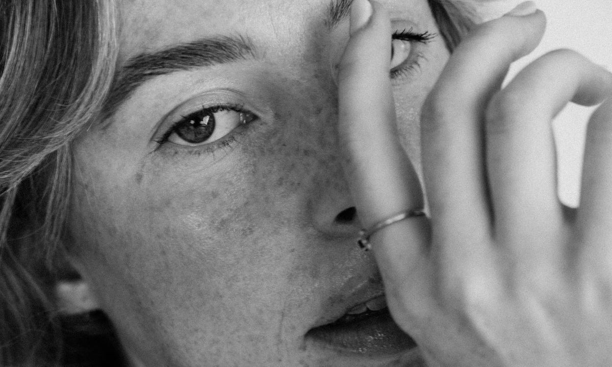 Black and white image of a lady touching her face