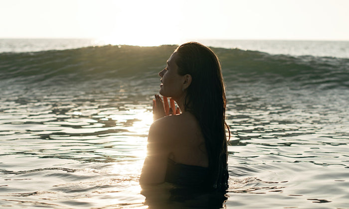 Lady swimming in ocean at sunrise
