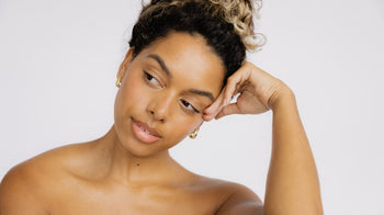 Woman with dark curly hair looks to the side