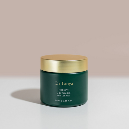 An emerald pot of day cream with a gold lid